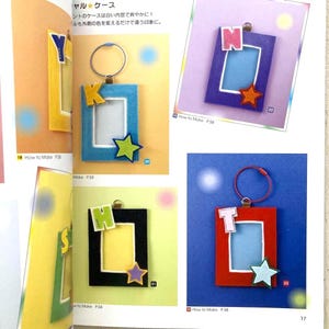 May include: A page from a craft book featuring handmade keychains. Each keychain has a rectangular frame with a letter, star, and a keyring. The frames are in blue, black, and red.