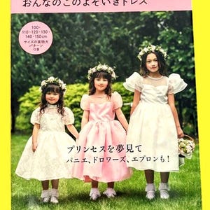 以下が含まれることがあります： フォーマルドレスを着た3人の少女が表紙に描かれた本。少女たちは白いドレスとピンクのドレスを着ており、花冠を被っている。表紙の上部と下部には日本語のテキストが書かれている。フォーマルシーン、発表会、七五三、ハロウィンのための本。