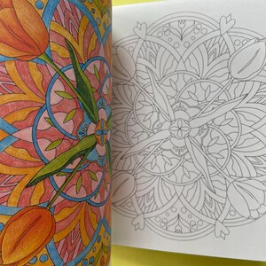 May include: A coloring book page featuring a circular mandala design with tulip motifs. The left side shows a partially colored version in shades of orange, pink, blue, and green, while the right side displays the identical black and white line art.