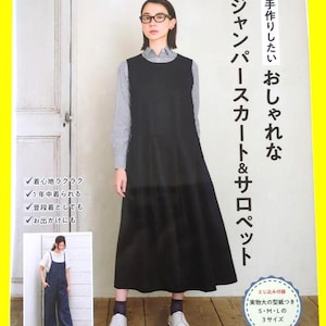 以下が含まれることがあります： 黒いジャンパースカートとグレーと白のストライプ柄の襟付きシャツを着用した人物が写る手芸本の表紙。表紙には日本語のテキスト、デニムのサロペットを着た人物の小さな写真、白い文字が書かれた青い円形のバッジが含まれています。