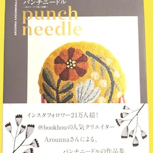 Könnte beinhalten: Buchcover mit dem Titel "punch needle" in Goldbuchstaben. Das Bild zeigt eine Nahaufnahme eines gelben, orangefarbenen und braunen Blumendesigns. Japanischer Text und Illustrationen sind ebenfalls vorhanden.