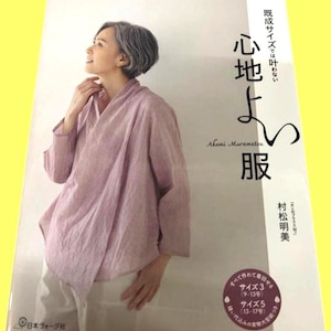 May include: A softcover book titled Heart Warming Life Series featuring a light purple, long-sleeved, wrap-style blouse with a textured fabric. The cover displays Japanese text, the author's name Akemi Muramatsu, and a circular graphic indicating sizes.