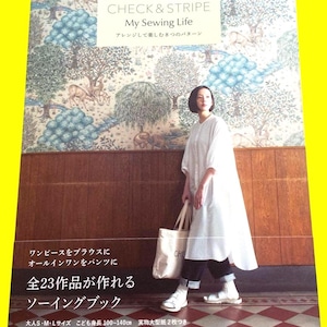 May include: A book titled "CHECK & STRIPE My Sewing Life" with Japanese text, featuring sewing patterns. The cover shows a woman in a white dress, holding a tote bag. The book promises 23 projects, with sizes for adults and children.