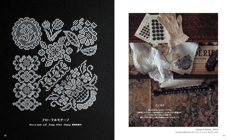 Op de afbeelding: Dubbele pagina van een boek met witte kruissteek bloempatronen op een zwarte achtergrond, met Japanse tekst. De rechterkant toont vintage items: knopen, een kanten handschoen, een zakdoek en een decoratief item.