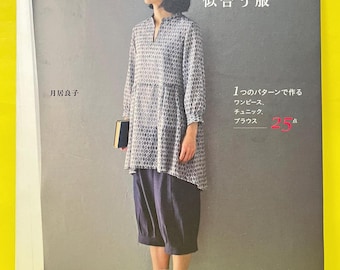 Può includere: Copertina di un libro di cucito che mostra una persona con una tunica a maniche lunghe con motivo a rombi grigi e bianchi, scollo a fessura e pantaloni blu scuro a metà polpaccio. Include testo in giapponese e il numero 25 in rosso.