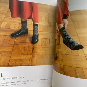 May include: A pair of black and white socks featuring a repeating herringbone pattern with solid black cuffs and toe sections. The socks are shown in a printed book layout alongside text that includes the Japanese title and How to make: P.58.