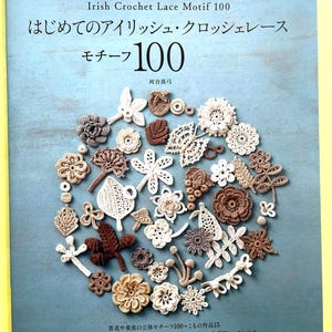 以下が含まれることがあります： 「はじめてのアイリッシュ・クロッシェレース モチーフ100」というタイトルのソフトカバーの教本。水色の表紙の中央には、白、ベージュ、茶色の様々なかぎ針編みのレースモチーフが円形に配置されています。