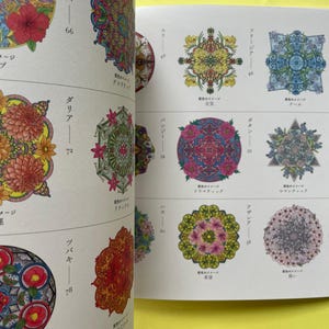 May include: A coloring book page featuring multiple circular and geometric floral mandala illustrations. Each design is intricately colored with vibrant hues including red, pink, yellow, blue, and green. Japanese text labels and page numbers accompany each pattern.