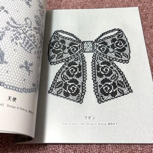 Op de afbeelding: Pagina uit een knutselboek met een zwart-wit kruissteek strik ontwerp. De strik is gedecoreerd met bloemmotieven. Japanse tekst bevat het woord "Ribbon" en stikinstructies.