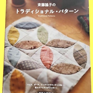 May include: A book cover featuring a quilted patchwork design with leaf-shaped patterns in various colors. The title reads "Traditional Patterns" in English and Japanese. The book is about patchwork and quilting.