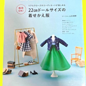 Op de afbeelding: Een Japans naaiboek voor poppenkleding, met een miniatuur outfit met een groene rok en een spijkerjasje. De omslag toont diverse poppenkleine kleding en accessoires. Het boek bevat patronen voor poppen van 22 cm.