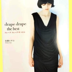 May include: A book cover with the title "drape drape the best" in white text. The cover features a woman wearing a black sleeveless dress with a draped neckline. The background is a soft yellow.