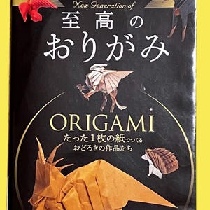 May include: A book cover with the title "Origami" in English and Japanese. The cover features origami animal figures in brown and white, including a dinosaur, dog, and hedgehog, against a black background.