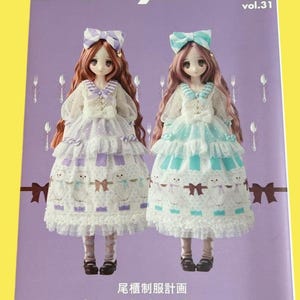 以下が含まれることがあります： フリルドレスとリボンを着た2体の人形が特徴の雑誌の表紙。雑誌のタイトル「Dollybird」が上部にあり、「vol.31」が隣にあります。「be my baby! Cherry」というテキストが下部にあり、その上に日本語のテキストがあります。背景は紫です。