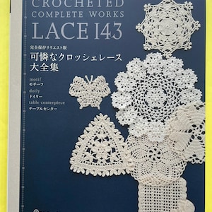 Może przedstawiać: Książka rzemieślnicza zatytułowana Crocheted Complete Works Lace 143 z ciemnoniebieską okładką. Okładka przedstawia białe szydełkowe wzory koronkowe, w tym motyla, trójkąt i kilka okrągłych serwetek z japońskim tekstem na przedniej stronie.
