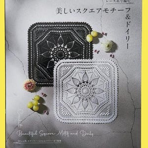 May include: A book cover featuring two crocheted square doilies, one black and one white, with floral patterns. The text reads "Beautiful Square Motif and Doily" and includes Japanese text. The book is by applemints.