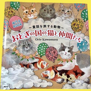 May include: A children's colouring book titled "Cats and Friends in Fairyland" by Orie Kawamura. The cover features illustrations of cats, koi fish, and balloons. The book has Japanese text and the word "BOOK" in a pink circle.