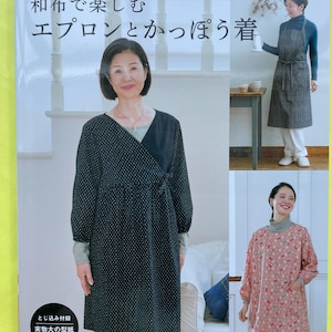 以下が含まれることがあります： 和布で楽しむエプロンとかっぽう着というタイトルの手芸本。表紙には、黒い水玉模様や赤い花柄など、様々なスタイルの長袖エプロンや割烹着のデザインが3種類掲載されており、実物大の型紙付きであることが記載されています。