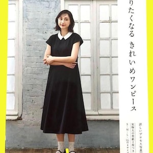 Peut inclure: Une femme porte une robe noire avec un col blanc, des chaussures noires et des chaussettes blanches à pois. L'image contient du texte japonais et un cadre jaune. La robe est mi-longue et à manches courtes.