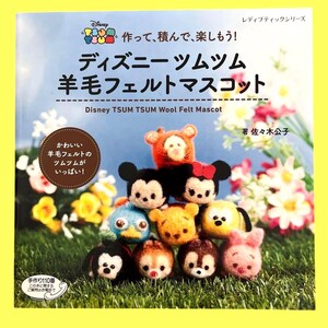 May include: A book cover featuring a stack of Disney Tsum Tsum wool felt mascots. The title reads "Disney TSUM TSUM Wool Felt Mascot" in Japanese and English. The mascots are colorful and stacked on a grassy surface.
