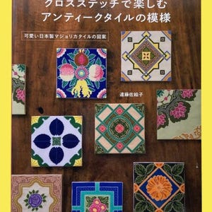 Może przedstawiać: Okładka książki z tytułem "CROSS-STITCH x ANTIQUE TILE DESIGN" w języku angielskim i japońskim. Prezentuje różne kolorowe, kwadratowe wzory płytek z motywami kwiatowymi i geometrycznymi. Widoczny jest również tekst "可愛い日本製マジョリカタイルの図案".