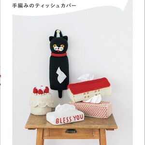 May include: A collection of handmade crochet tissue box covers in various shapes and colors. Includes a black cat-shaped cover, a cake-shaped cover, and several rectangular covers. One cover has the text "BLESS YOU".