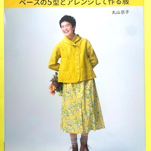 May include: A book cover titled かたがみスタイル発 ベースの5型とアレンジして作る服 by 丸山京子. The cover features a person wearing a mustard yellow long-sleeved jacket with a wide collar and a yellow floral print skirt, paired with brown lace-up boots.