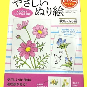 Könnte beinhalten: Ein japanisches Malbuch mit dem Titel "Einfaches Ausmalen". Das Cover zeigt Illustrationen von rosa Kosmosblumen und blauen Blumen. Der Text auf dem Cover enthält "Recrea Books" und "Herbstblüten-Edition".