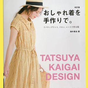 以下が含まれることがあります： 「おしゃれ着を手作りで。」というタイトルのソフトカバー本。表紙には、黄色い花柄のワンピースと麦わら帽子を身につけた人物が写っている。表紙には大きなピンク色の文字で「TATSUYA KAIGAI DESIGN」と書かれており、日本語のテキストも含まれている。