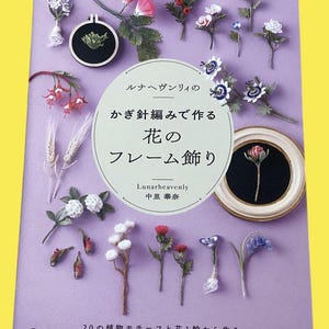 May include: A book cover in Japanese with the title "Flowers Frame Decoration", featuring handmade floral decorations. The cover is purple with the text "Lunarheavenly" and "20 Plant Motifs and 1 Flower Ring".