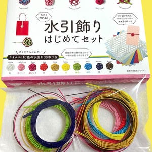 以下が含まれることがあります： 水引アート制作のクラフトキット。カラフルな紐、紙、説明書が入った箱です。箱には、白、ピンク、赤、金、黄、緑、青、紫、茶色など、さまざまな色の水引紐が含まれています。箱のテキストは「水引アートスターターセット」と書かれています。