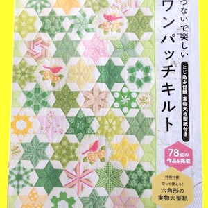 Peut inclure: Couverture de livre de patchwork coloré avec des motifs d'étoiles et d'hexagones verts, jaunes et roses. Le livre contient du texte japonais et des illustrations d'oiseaux et de fleurs. Le livre est pour faire des courtepointes.