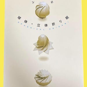May include: A book cover featuring three origami models in shades of white and beige. The title "Spherical Origami" is displayed in English and Japanese characters. The author's name is also visible.
