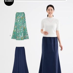 以下が含まれることがあります： 女性が白いトップスと組み合わせた、ウエストゴムのネイビーブルーのマーメイドスカートをモデルにしています。画像には、花柄のスカートと無地のネイビーブルーのスカートも表示されています。画像には「Elastic Waist Mermaid Skirt」と書かれています。