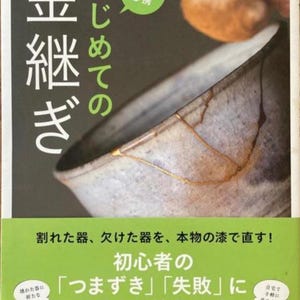 May include: A book cover featuring a Kintsugi bowl with gold-filled cracks. Japanese text includes "Kintsugi" and "Beginner's Guide." The cover also has text in Japanese and illustrations of a broken bowl being repaired.