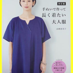 Könnte beinhalten: Eine Frau trägt ein dunkelblaues Kleid mit V-Ausschnitt und kurzen Ärmeln. Das Kleid hat weiße Nähte entlang des Halsausschnitts und der Ärmel. Das Bild ist ein Buchcover mit japanischem Text und einem gelben Rand.