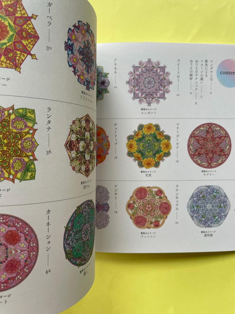 May include: A book page featuring a grid of colorful circular mandala illustrations with floral motifs. Each design is labeled with Japanese text and page numbers, showcasing intricate patterns in shades of pink, yellow, green, and blue.