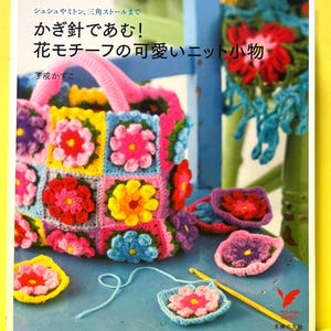 May include: A book cover featuring a crocheted bag and flower motifs. The bag is made of colorful squares with pink, yellow, and blue flowers. The text on the cover is in Japanese. Crochet hooks and additional crocheted flowers are also visible.