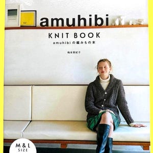 以下が含まれることがあります： 「amuhibi KNIT BOOK」の表紙。茶色のニットカーディガン、白いタートルネック、緑のチェック柄スカート、黒いブーツを履いた女性が写っています。本は白いソファの上にあります。日本語のテキストが含まれています。