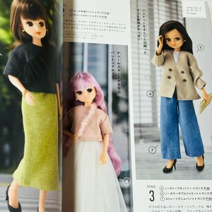 Op de afbeelding: Drie modepoppen worden getoond in een tijdschrift. E&eacute;n pop draagt een zwarte top en een groene rok. Een andere pop draagt een roze top en een witte rok. De derde pop draagt een beige jasje en een blauwe jeans.