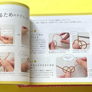 Puede incluir: Libro abierto con texto japon&eacute;s e ilustraciones paso a paso que demuestran t&eacute;cnicas de anudado. Las p&aacute;ginas est&aacute;n amarillentas y las im&aacute;genes muestran manos manipulando cuerdas para crear nudos intrincados. El texto est&aacute; en japon&eacute;s.