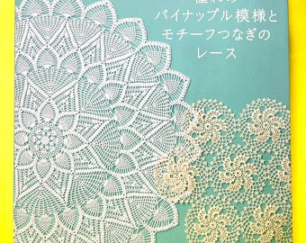 May include: A teal-coloured instructional book titled Crochet Lace featuring white intricate pineapple and circular motif patterns on the cover. The text includes Japanese characters and the English words Crochet Lace, showcasing detailed needlework designs.