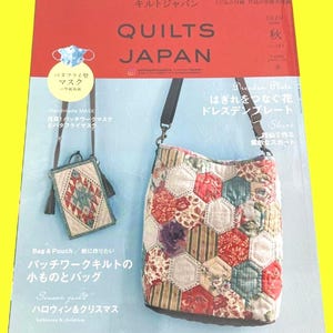 以下が含まれることがあります： 「キルトジャパン」というタイトルの雑誌の表紙。2020年秋号。パッチワークのバッグと小さなポーチが特徴で、どちらも複雑なデザイン。雑誌には、蝶のマスクも掲載されています。