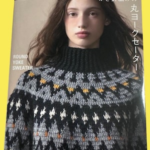 May include: A book cover featuring a woman wearing a black, gray, and yellow round yoke sweater. The book title is "Round Yoke Sweater" with Japanese text. The cover has the "applemints" logo.