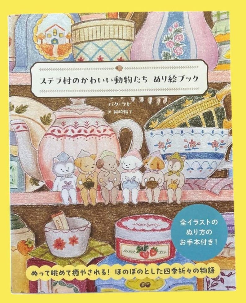 May include: A colorful illustration of a coloring book featuring adorable animal characters. The book's cover displays the title in Japanese, along with images of teacups, teapots, and jars. The illustration has a whimsical, storybook style.