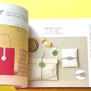 Puede incluir: Una p&aacute;gina de un libro de manualidades que muestra ideas para envolver regalos. Se muestra una bolsa de regalo roja con una flor blanca y una bolsa marr&oacute;n con lunares blancos. Otros ejemplos incluyen paquetes envueltos con nudos decorativos.