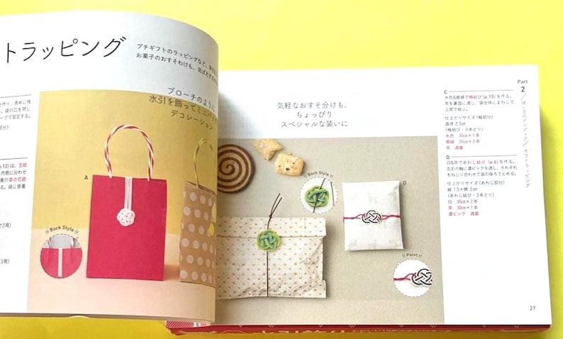 Puede incluir: Una p&aacute;gina de un libro de manualidades que muestra ideas para envolver regalos. Se muestra una bolsa de regalo roja con una flor blanca y una bolsa marr&oacute;n con lunares blancos. Otros ejemplos incluyen paquetes envueltos con nudos decorativos.