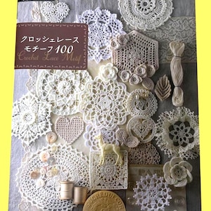 Peut inclure: Divers motifs de dentelle crochetée blanche, incluant des napperons, des cœurs et des motifs floraux, disposés sur un fond gris. L'image présente également un livre intitulé "Crochet Lace Motif 100" et de petits éléments décoratifs.