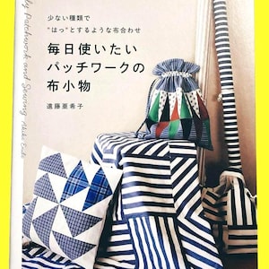 Peut inclure: Une couverture de livre avec du texte japonais et une bordure jaune. Le livre s'intitule "Daily Patchwork and Sewing" et présente un sac à cordon patchwork, un oreiller et un tissu rayé. Le sac a des triangles verts, rouges et blancs.