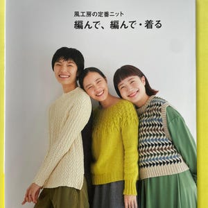 Puede incluir: Un libro de patrones de tejido titulado Let's knit series, que muestra a tres personas vistiendo un suéter de punto trenzado color crema, un suéter texturizado verde lima y un chaleco de punto con patrón geométrico beige y azul sobre un vestido verde.